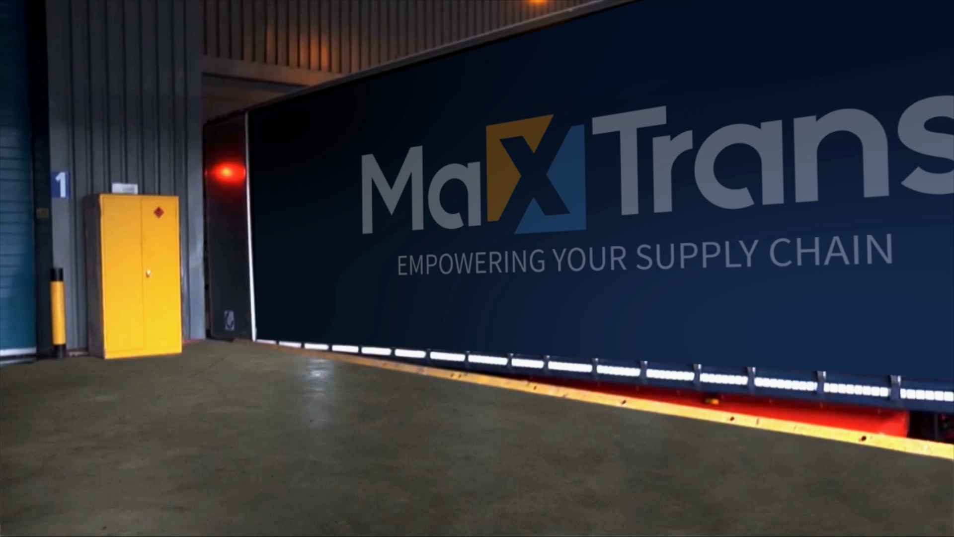 A Maxtrans Dry Van Trailer back up to a loading dock 